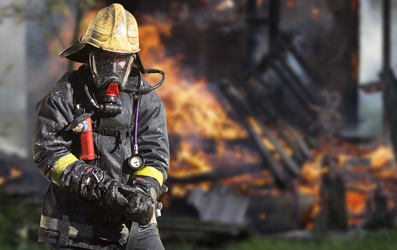 Brookfield fire fighter in front of burned home